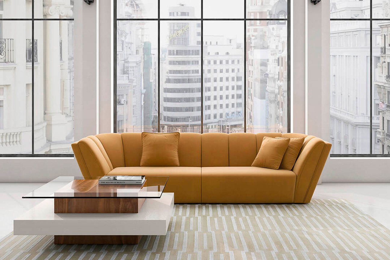 Contemporary living room with Bowie Stripe sofa upholstered in yellow velvet and coffee table in wood and glass.