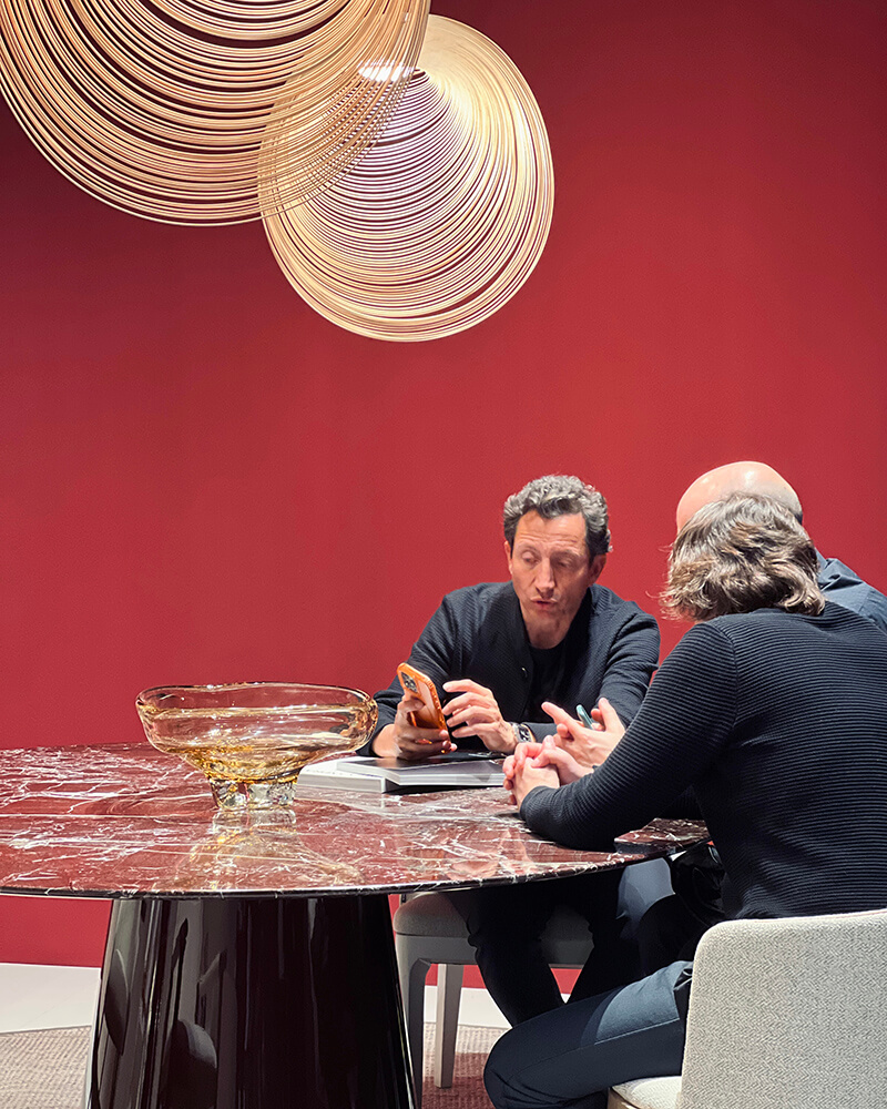 Stand de ALEXANDRA en Salone del Mobile Milano con diseño de interiorismo contemporáneo y detalles de color que aportan calidez y sofisticación.